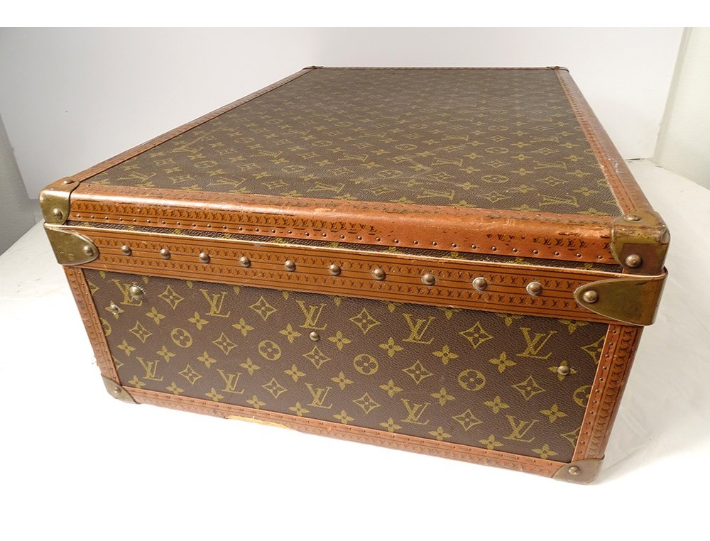 At Auction: Louis Vuitton - Alzer monogram suitcase, numbered 933328, in LV  motif printed brown canvas with leather edging and stamped studs and locks,  containing a single tray and straps, labelled with