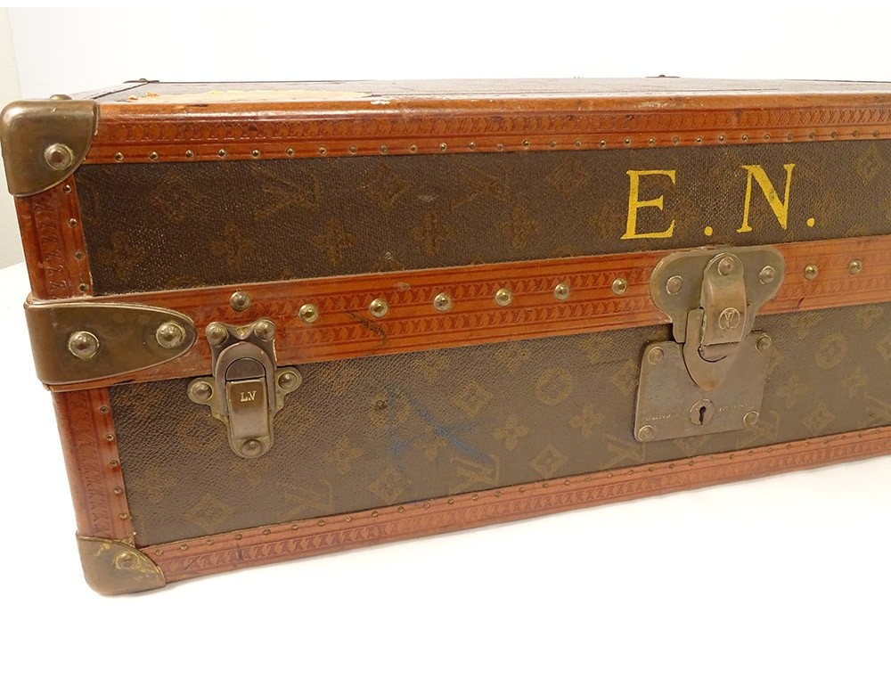 At Auction: Louis Vuitton - Alzer monogram suitcase, numbered 933328, in LV  motif printed brown canvas with leather edging and stamped studs and locks,  containing a single tray and straps, labelled with